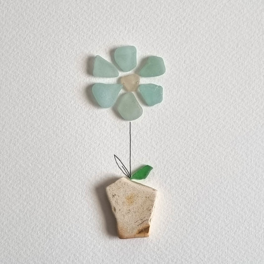 Seaglass artwork of a blue flower in a pot